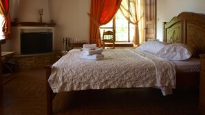 Una camera da letto con un letto grande, una testata in legno, un camino e una finestra con tende.