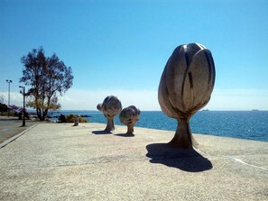 A coastal walkway with sculptures and a clear view of the sea.