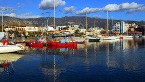 A marina with boats docked, buildings in the background, and mountains in the distance. - Casa Anna Maria in Volos (Volos)