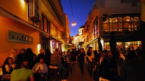 A crowded street with outdoor seating at various establishments, suggesting a lively urban area. - Casa Anna Maria in Volos (Volos)