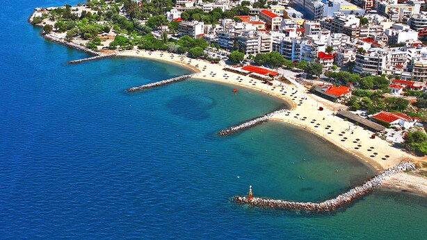 An aerial view of a coastal area with a beach, buildings, and a breakwater. - Casa Anna Maria in Volos (Volos)