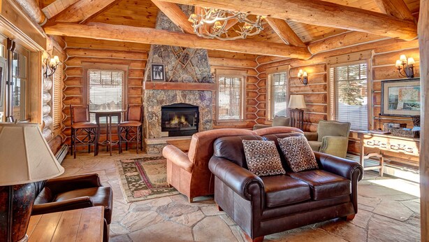 A log cabin interior with a fireplace, leather sofa, and stone flooring. - Stunning 3 BR Townhome in Keystone! Enjoy the complex hot tub after a long day o (Keystone)