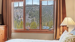 A bedroom with a large window offering a view of a forested mountain. - Stunning 3 BR Townhome in Keystone! Enjoy the complex hot tub after a long day o (Keystone)