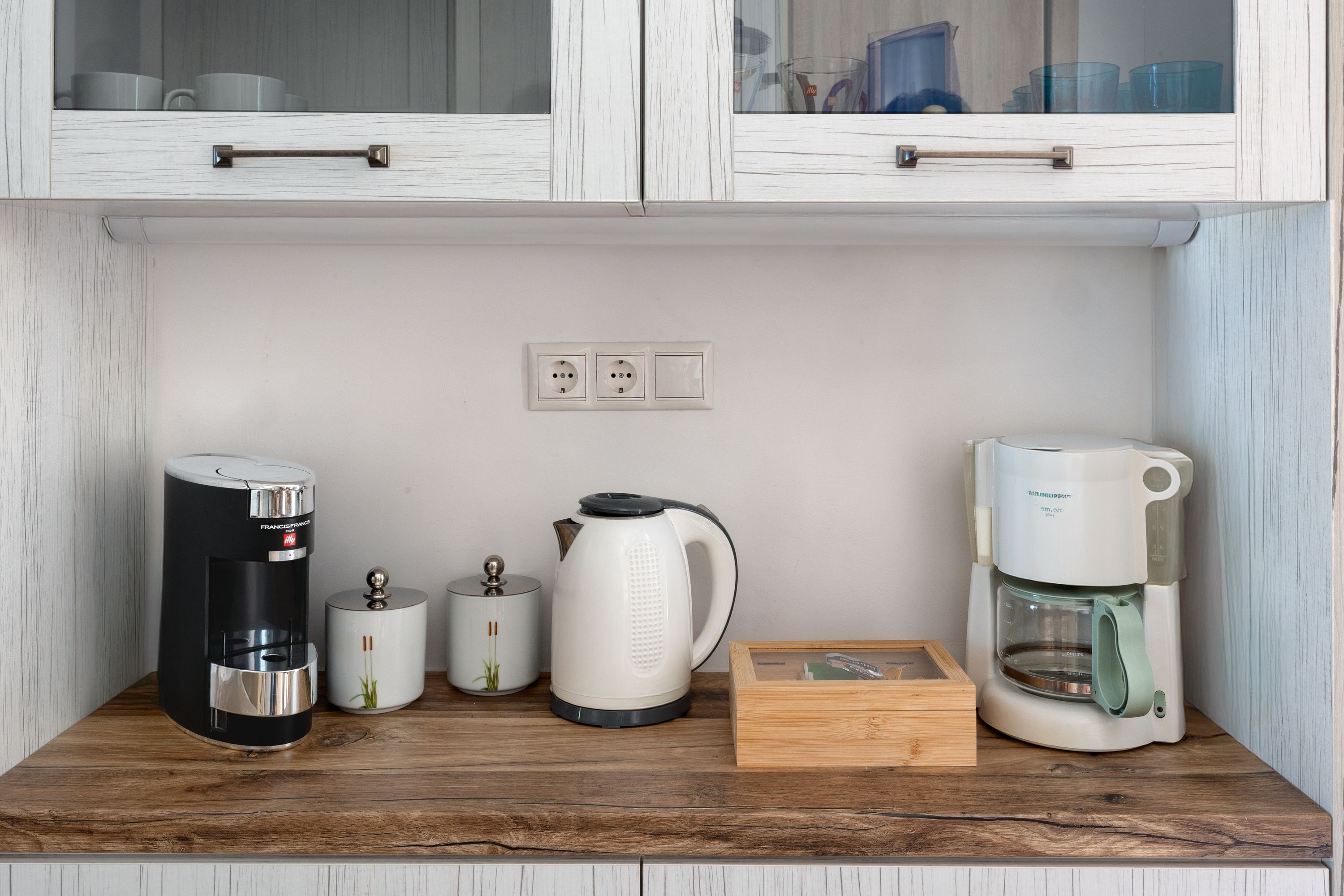 Een aanrecht met een koffiezetapparaat, waterkoker en een doos.