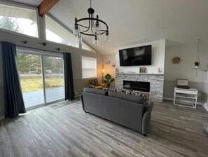 Relax in this spacious living room with a comfortable sofa, fireplace, and flat-screen TV.