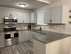Enjoy cooking in this well-equipped kitchen with stainless steel appliances, a modern faucet, and ample cabinetry.