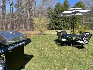 Enjoy al fresco dining on the lawn, where a barbecue grill and shaded dining area await.