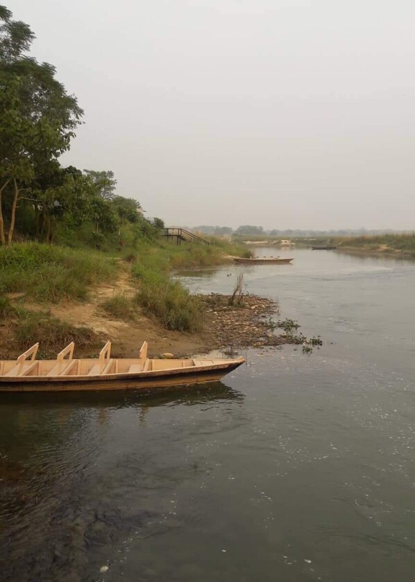 Un río tranquilo con una barca de madera amarrada en la orilla izquierda.