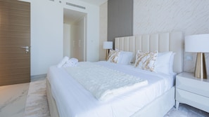 A modern hotel room with a large bed, a bedside table with a lamp, and a wardrobe. - Nasma Luxury Stays - One Park Avenue (Dubai)