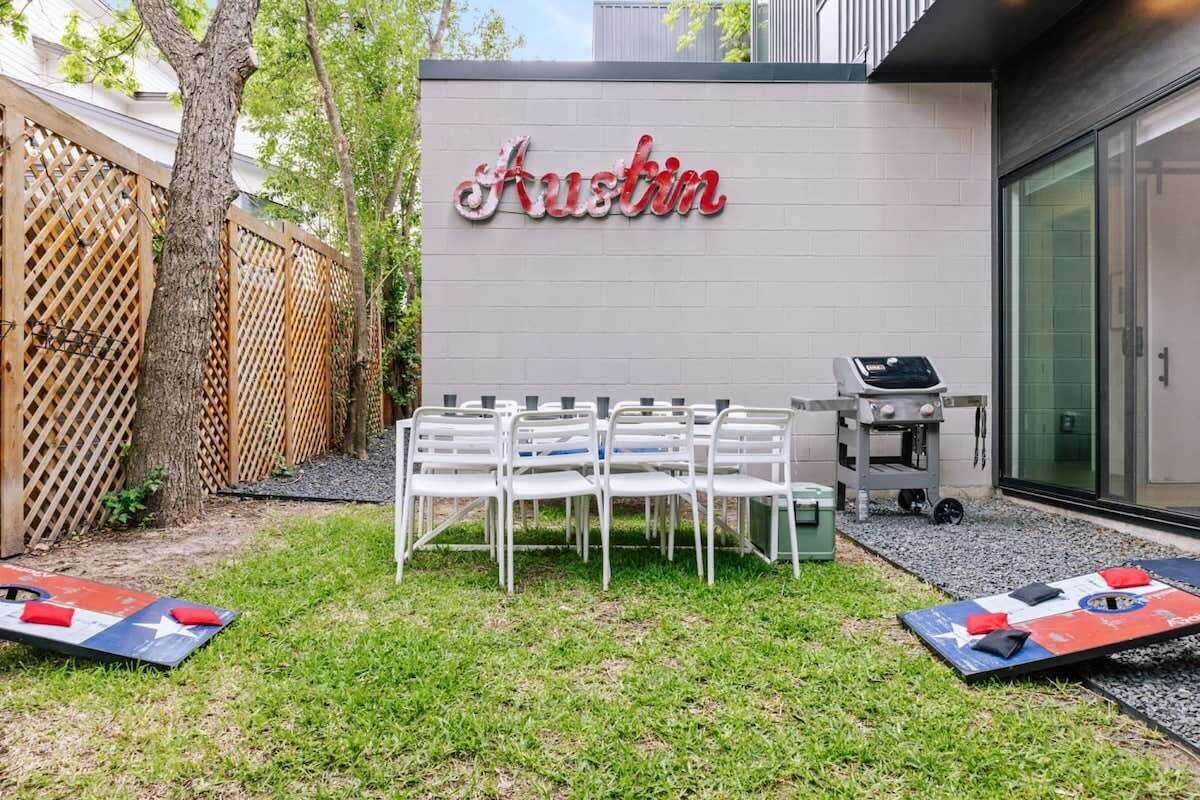 Un patio con un letrero que dice 'Austin', asientos exteriores y una parrilla.