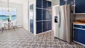 A modern kitchen with a large island, a built-in refrigerator, and a view of the outdoors. - Minutes from Downtown Easton and St. Michaels | Pool | Private Dock (Easton)