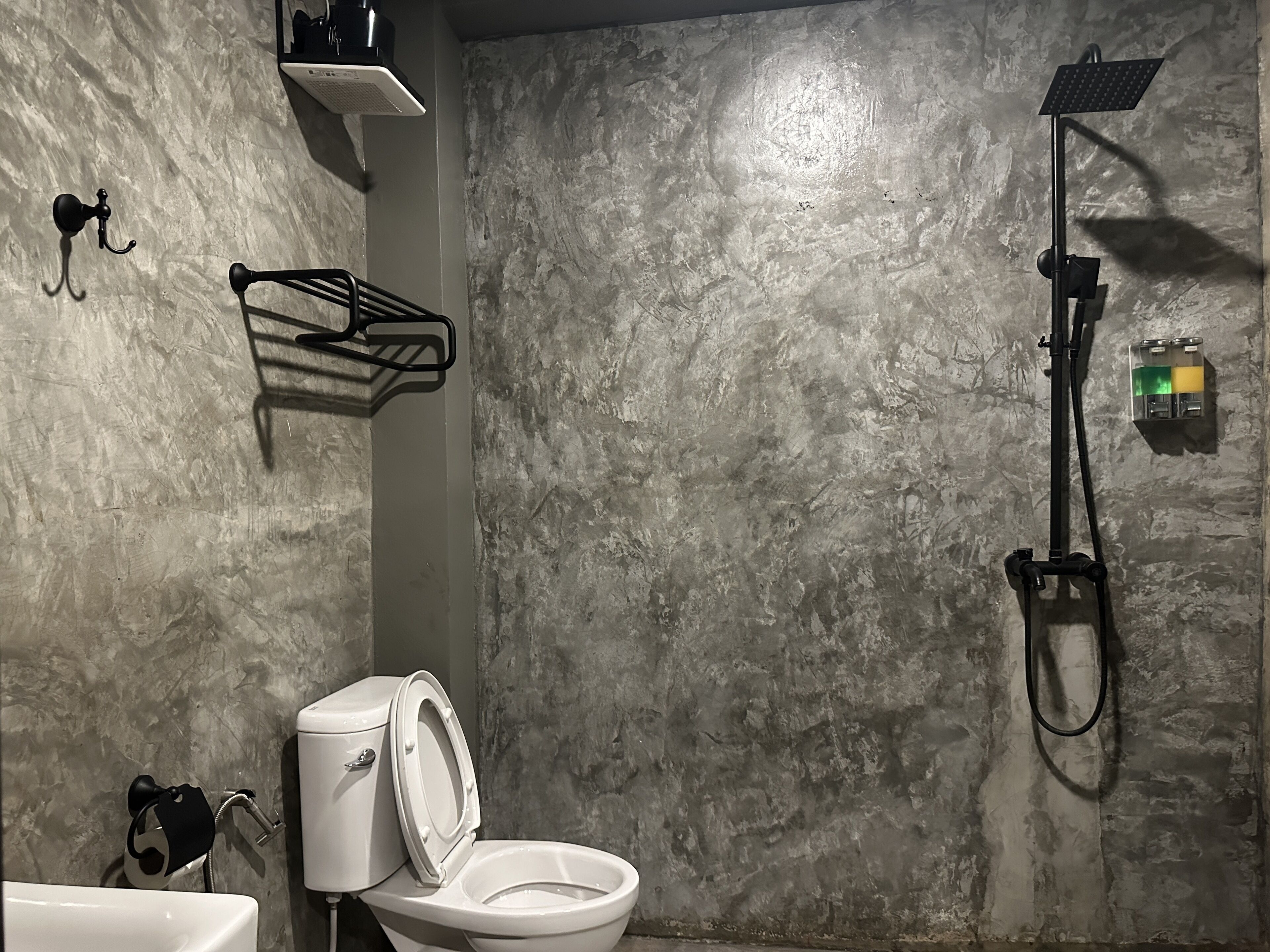 A bathroom with a toilet, a shower, and a sink.