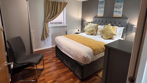 Um quarto moderno com uma cama, mesas de cabeceira, uma cadeira e um guarda-roupa.