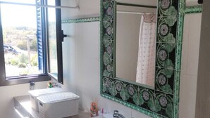 A bathroom with a large mirror, two sinks, and a window.