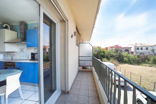Un balcon doté d’un coin cuisine, d’une table à manger et offrant une vue sur les environs.