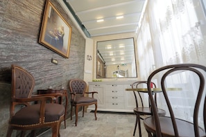 Enjoy meals in this stylish dining area with a large mirror, comfortable chairs, and a small table.