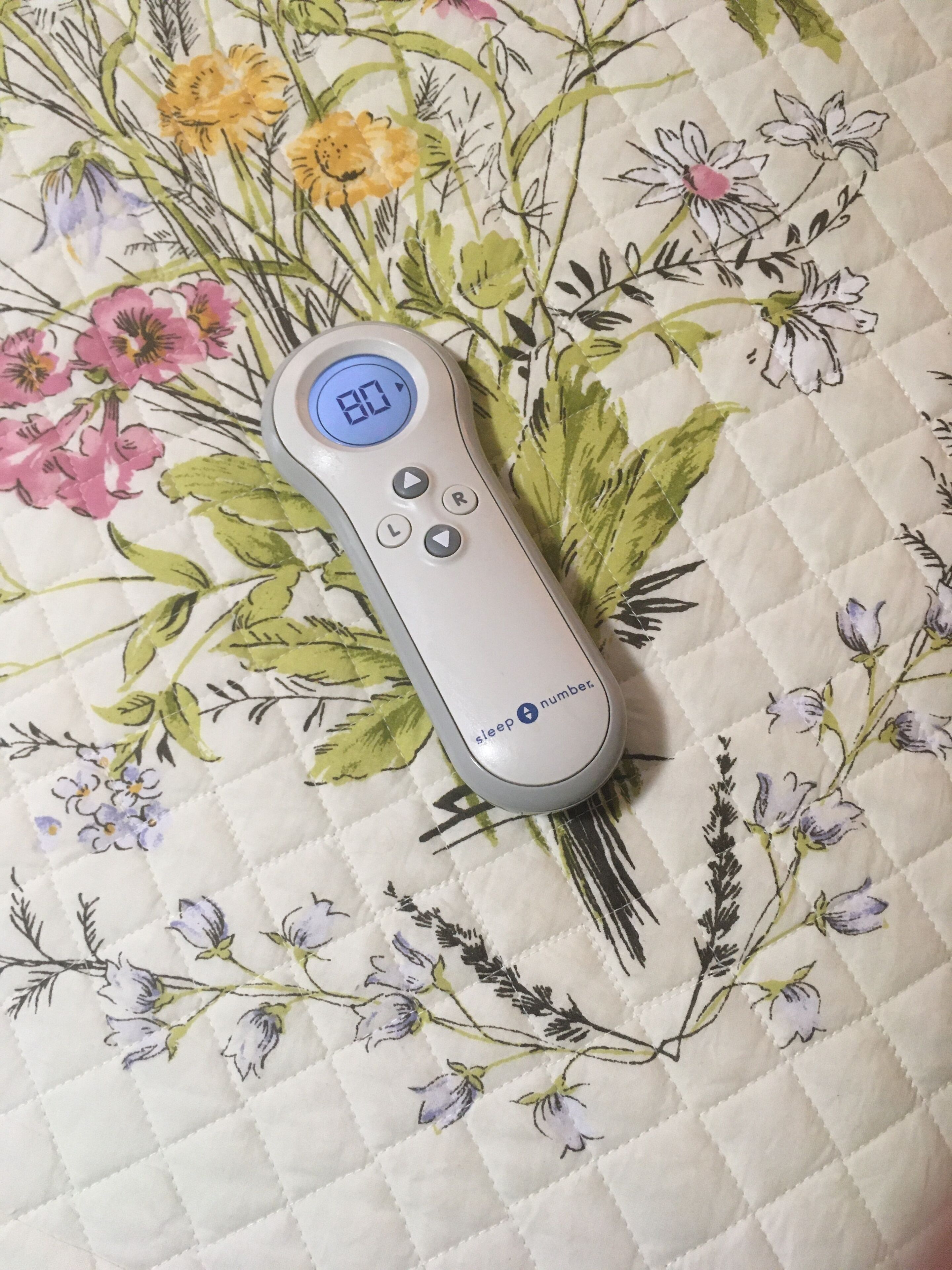 Un dispositif de suivi du sommeil intégré à un tissu matelassé orné de motifs floraux.