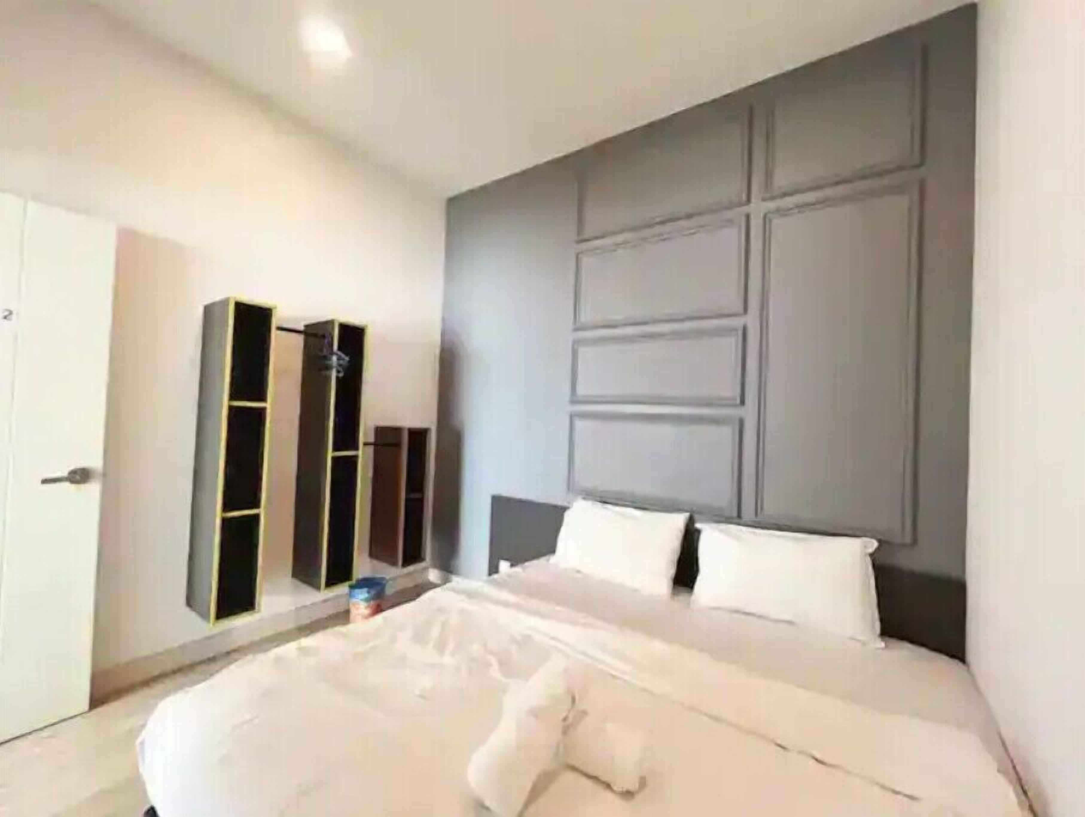 A modern bedroom with a large bed, built-in wardrobes, and a grey headboard.