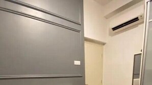 A bedroom with a bed, a headboard, a wall-mounted air conditioner, and a door leading to a bathroom. - Signature Premium Suite KLCC Arte+ 2R2B (Kuala Lumpur)