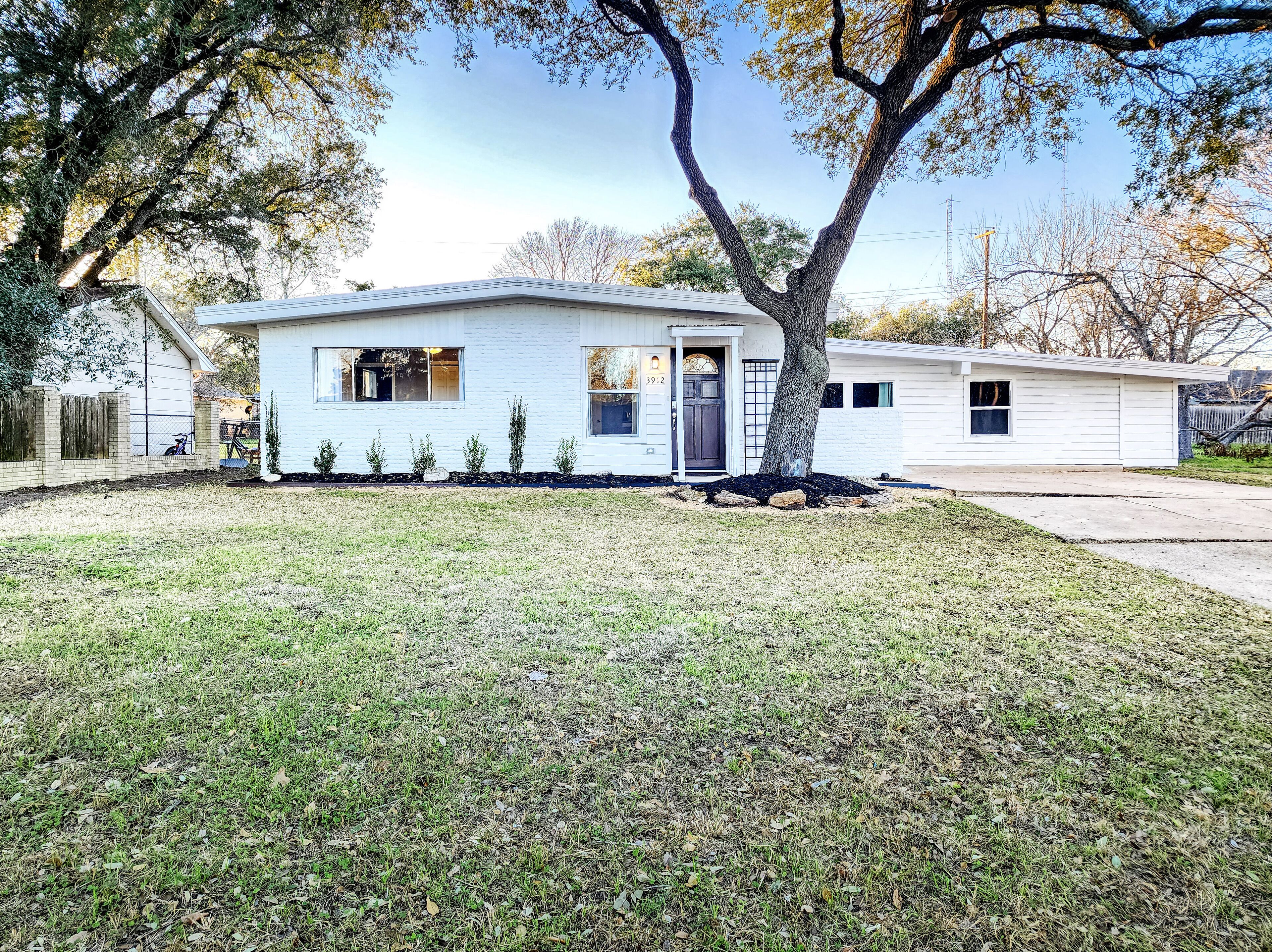 Einbungalow mit Veranda, Garage und kleinem Vorgarten.