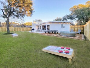 A backyard with a barbecue area, a hot tub, and a picnic table.