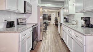 A modern kitchen with white cabinets, a microwave, a toaster, and a coffee maker. - 5mins to Kyle Field, 5BR w Private Backyard & Pool (Bryan)