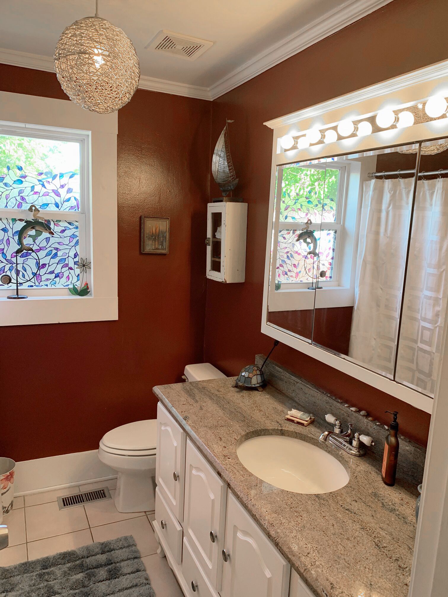 A bathroom with a vanity, sink, and mirror.