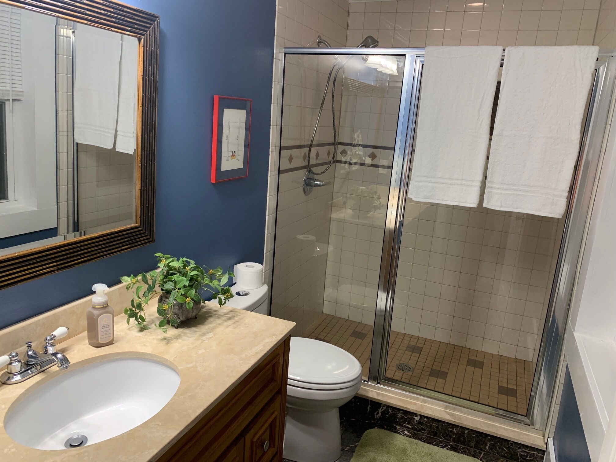 Une salle de bain équipée d’un lavabo, de toilettes et d’une douche à parois de verre.