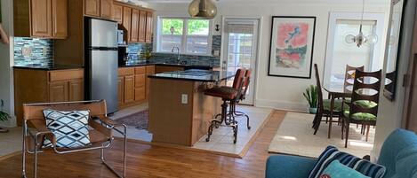 A spacious living area with a kitchen, dining area, and a small island.