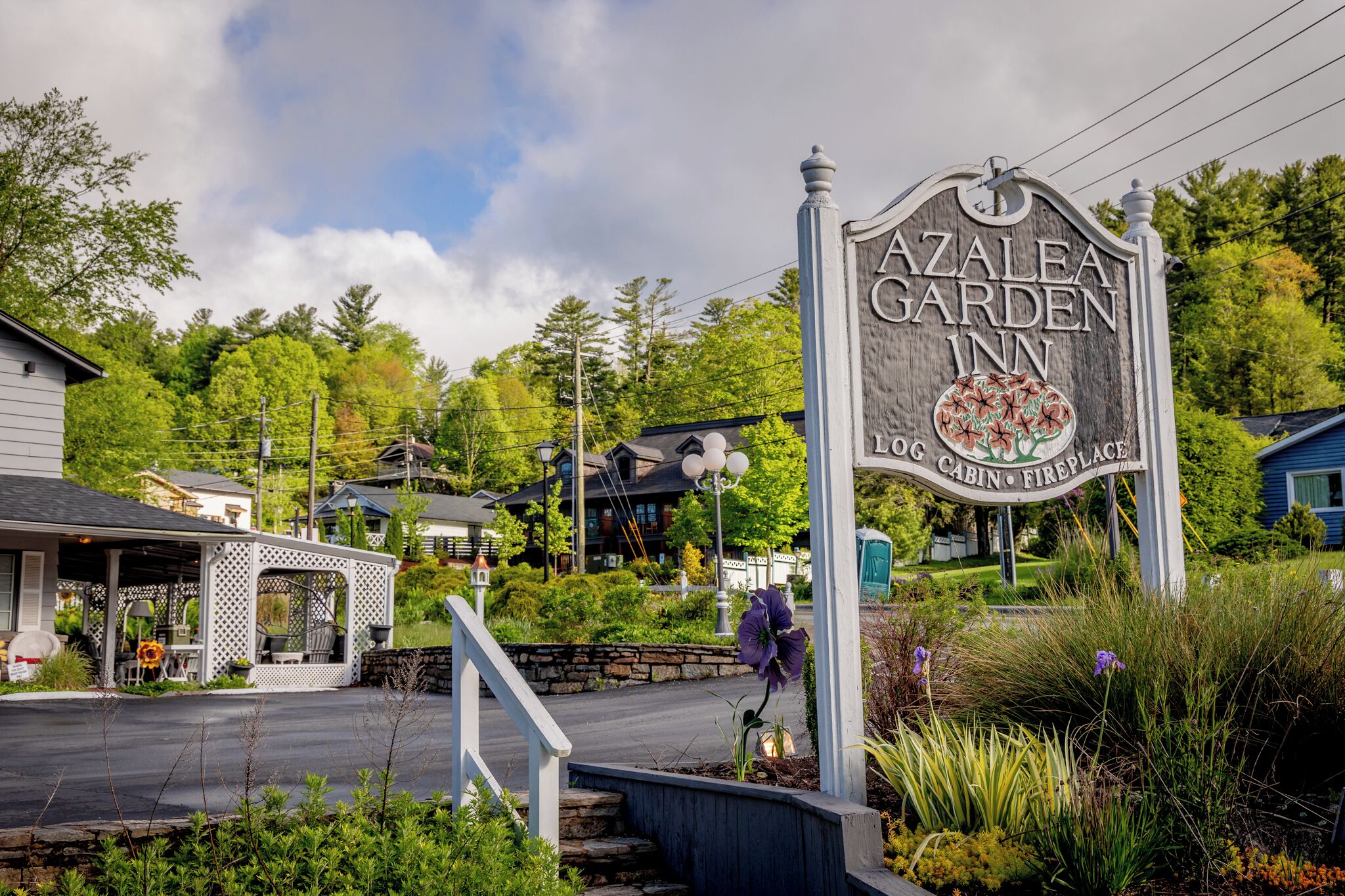 A sign for Azalea Garden Inn with a log cabin and fireplace symbol.