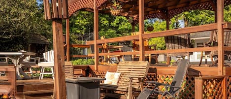 Eine Holzpergola mit Sitzgelegenheit und einer hängenden Pflanzampel.