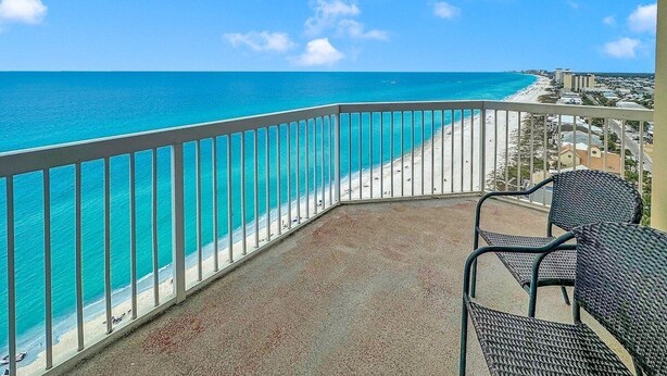 A balcony with a view of a beach and ocean.