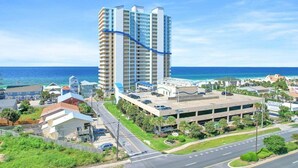 A high-rise hotel with multiple floors, a parking garage, and a view of the ocean.