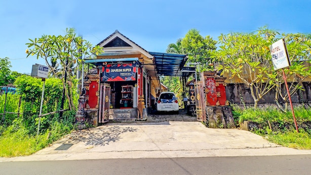 A hotel entrance with a sign for 'Djarium Super' and a 'Foto Copi' printing service. - Hotel O Sekar Jagat Near Pantai Baluk Rening (Negara)