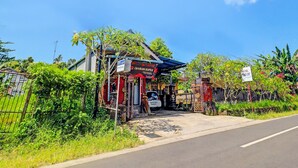 A small, rustic building with a sign indicating it is a hotel. - Hotel O Sekar Jagat Near Pantai Baluk Rening (Negara)