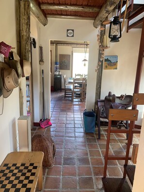 Un interior rústico con una mesa de cuadros, una cesta tejida y una silla de madera.