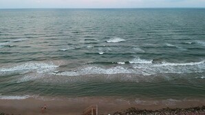 A beach with waves, a clear sky, and a distant horizon. - Banana Cabana – Gulf Views & Good Vibes (Surfside Beach)