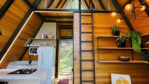 Interior acogedor de una cabaña con cocina, comedor y zona de descanso.
