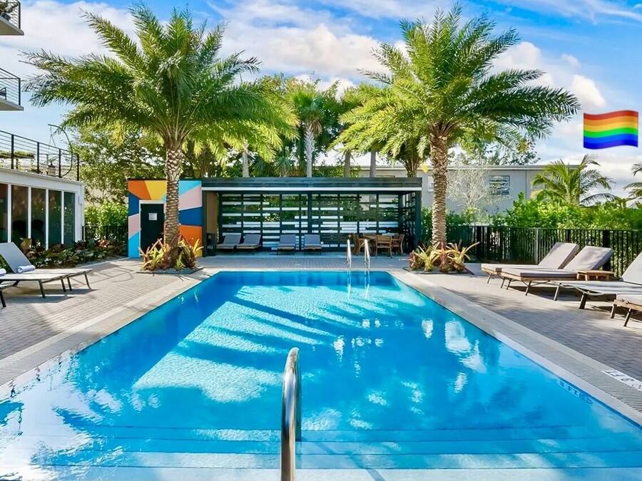 Una piscina al aire libre, sombrillas, sillones reclinables de piscina