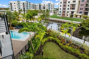 Un edificio residencial con piscina rodeado de exuberante vegetación y una fuente.
