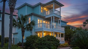 A two-story house with a balcony on the second floor, surrounded by greenery. - Spacious Seagrove Escape Cart Bikes Pool Near Beach (Santa Rosa Beach)