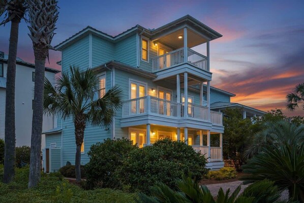 A two-story house with a balcony on the second floor, surrounded by greenery. - Spacious Seagrove Escape Cart Bikes Pool Near Beach (Santa Rosa Beach)