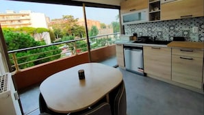 Eine moderne Küche mit großem Fenster, einem Essbereich und Blick auf die Stadt.
