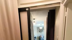 Ein Flur mit Marmorboden führt in einen Wohnbereich mit einer Couch und einer Wanduhr.