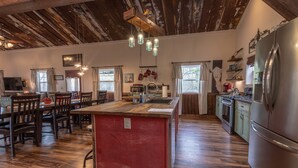 Una cocina amplia con una isla central, piso de madera y electrodomésticos modernos.
