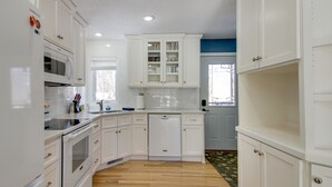 A modern kitchen with white cabinetry, a built-in microwave, and a dishwasher.