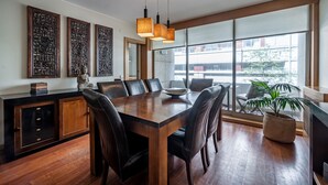 Un comedor moderno con una mesa de madera, sillas de cuero e iluminación colgante.