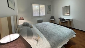 Un dormitorio con cama, escritorio y silla.