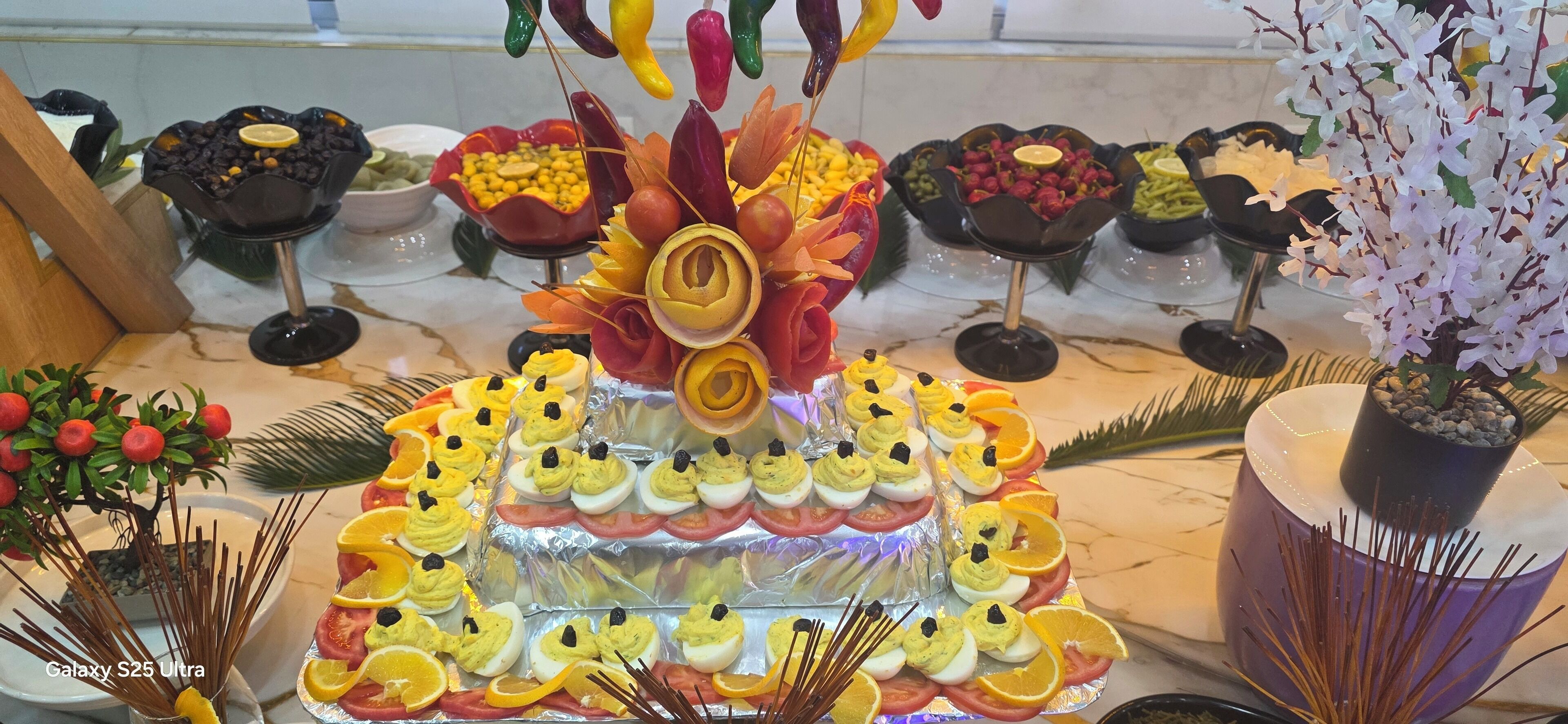 Un tavolo da buffet con diversi cibi e elementi decorativi.