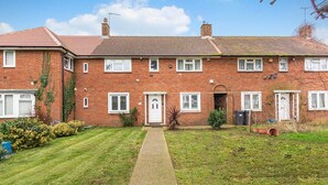 A two-story brick house with a front garden, a paved driveway, and a visible front door. - 3 Bed House Sleeps 8 -near Heathrow -free Parking (Hounslow)